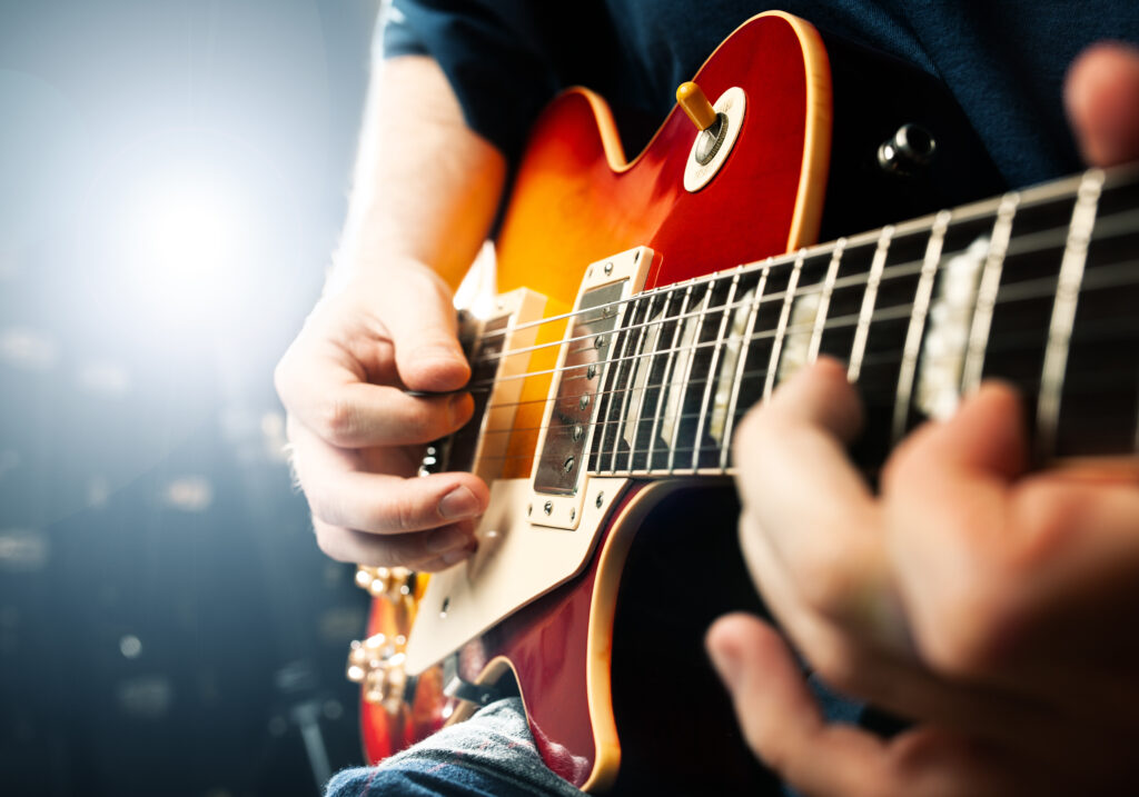 man playing on guitar close up view