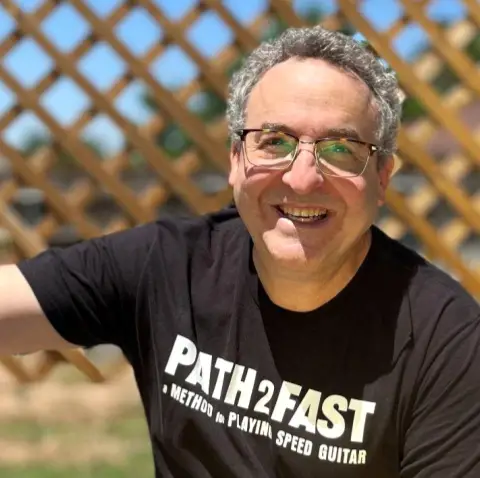 Headshot of a man wearing a black t shirt